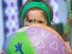 A girl holding a beach ball.