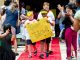 The yellow team carries their sign down the red carpet.