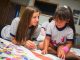 Child Life specialist Megan Billig and Isabel Ymbella create a pennant.