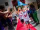 Employees and volunteers cheer siblings along the red carpet.