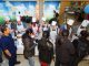 Employee volunteers dispense ice cream and toppings to those in line.