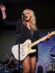Clare Dunn sings and plays guitar on stage.