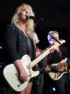 Clare Dunn sings and plays guitar on stage.