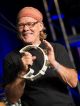A man plays the tambourine.