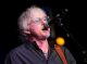 Mike Mills sings on stage.