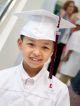 St. Jude patient Brantley smiles in his cap and gown.