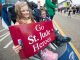 Children in a stroller cheering on the runners.