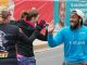 Runners high fiving a spectator.