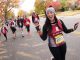 Woman running in the St. Jude half-marathon waving at the camera.