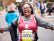 Woman smiling and pointing at her race bib.