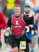 Man running in the St. Jude half-marathon waving at the camera.