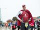 Man with cape posing in the St. Jude marathon.