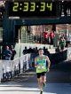 The first marathon runner crosses the finish line at 2 hours and 33 minutes.