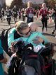 A mom hugs her St. Jude patient while runner pass.