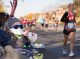 A young St. Jude patient and cheers on the runners with a cowbell.