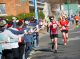 Runners grab cups of water for hydration as they race down Cooper Street.