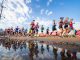 Runners race down the street.