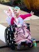 A St. Jude patient in a wheelchair holds out her hand to high five passing runners.