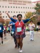 A St. Jude hero holds her hands up while running through the St. Jude campus.