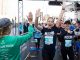 Runners high five a volunteer as they cross the finish line.