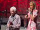 Robiie Krieger performing on stage with a woman singer.