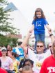 A young girl standing on her dad