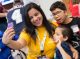 A woman takes a selfie with two children.