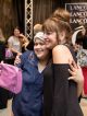 A prom attendee hugs another woman.