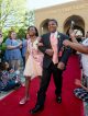 A young man and young woman walk the red carpet to the formal.