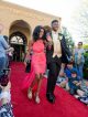 A young man and young woman walk the red carpet to the formal.