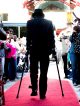 A young man walks the red carpet to the formal.