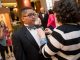 A woman pins a corsage on a young man.