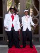Two young men walk the red carpet in their tuxedos.