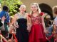 Two young ladies walk the red carpet in their formal gowns.