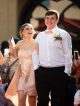 A girl smiles up at her date while walking the red carpet.