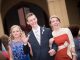 A young man escorting two young ladies down the red carpet.