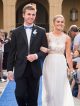 A teen couple walks the blue carpet together.