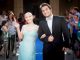 A young couple walks the blue carpet to prom.