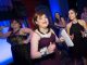 A group of girls dance at the prom.