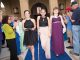 Three young ladies walking the blue carpet together.