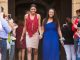 Two young ladies walking the blue carpet to prom.