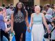 Two teens walk the blue carpet to prom together.