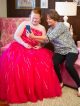 Woman and girl in prom dress looking at cell phone