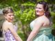Two girls in prom dresses posing for picture