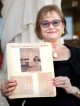 Karen Coffey Pascal holding a photo of her as a teenager when she volunteered as a "Candy Striper" at St. Jude