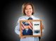 Racquel Collins, PhD, holding photo of herself from her time in the U.S. Air Force