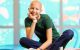St. Jude patient Madeline sits on a colorful block, legs crossed, resting her face in one hand.