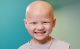 St. Jude patient Erma smiles while wearing a St. Jude T-shirt and a pink collar.