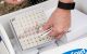 A hand putting vials of samples into a divided box.