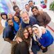A diverse group of St. Jude employees smile and pose for selfies.